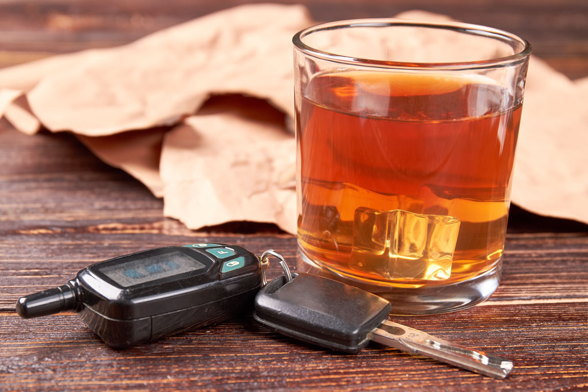 glass containing alcohol next to car keys